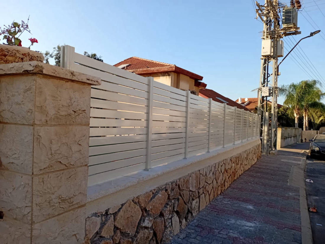 גדר אלומיניום לבנה לאורך קיר אבן · פרויקט של אביאל